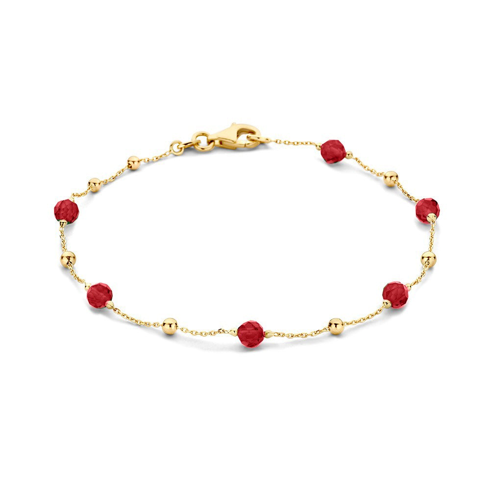 Bracelet en or jaune avec des zircons et des perles rouges.
