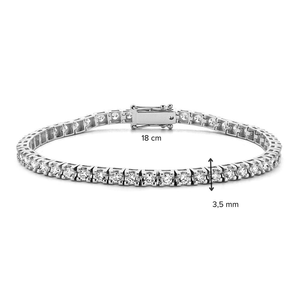 De Excellent Jewelry Witgouden Tennisarmband met 63 briljanten (3.01 crt, 14 karaat) heeft een veilige sluiting, is 18 cm lang en 3,5 mm breed; afmetingen zijn met zwarte pijlen aangegeven.
