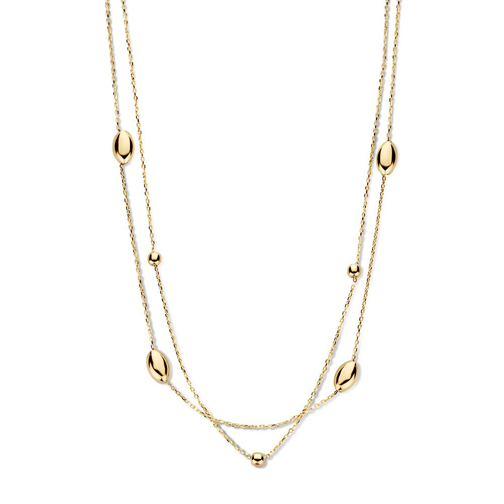 Collier en or jaune avec des éléments dorés, composé de chaînes délicates et de perles ovales.