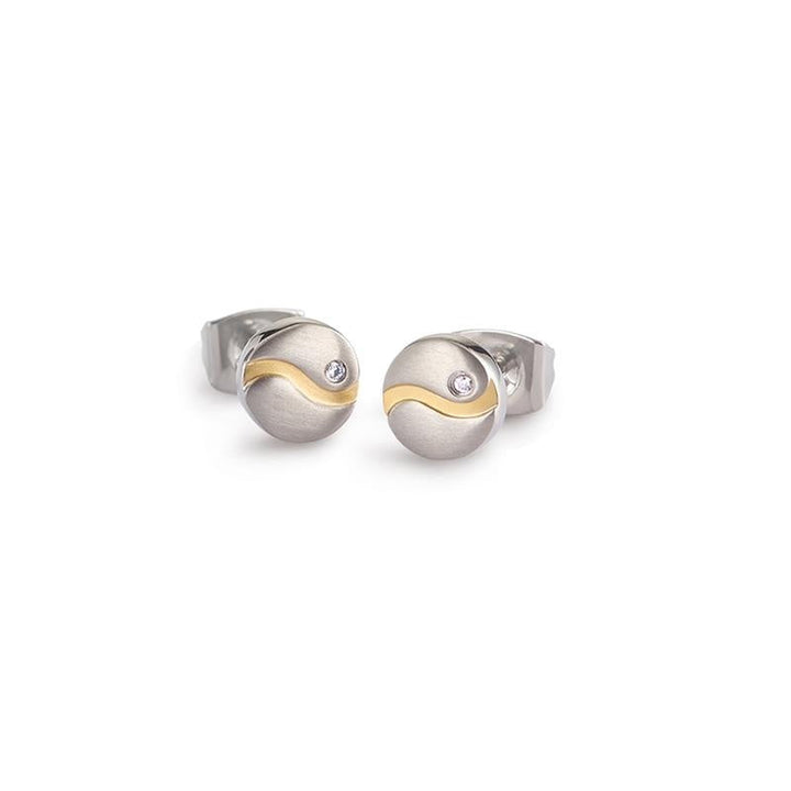 Een paar Boccia Titanium Bicolor-oorbellen (model 05028-04) met een matte zilveren afwerking, een gouden golvende lijn en een heldere edelsteen van 0,01 ct bovenaan elke ronde oorbel.