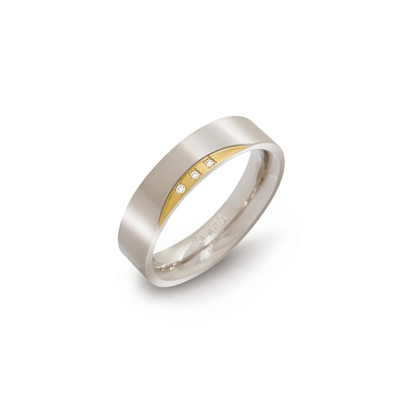 Bague en titane bicolore avec trois petits diamants sur une bande dorée.