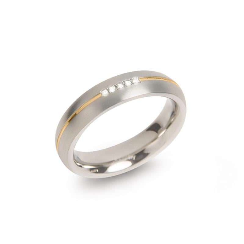 Bague en titane bicolore avec une ligne dorée et cinq petites pierres brillantes.
