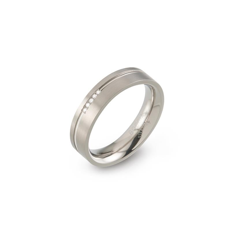 Bague en titane avec trois petites pierres brillantes et finition lisse.