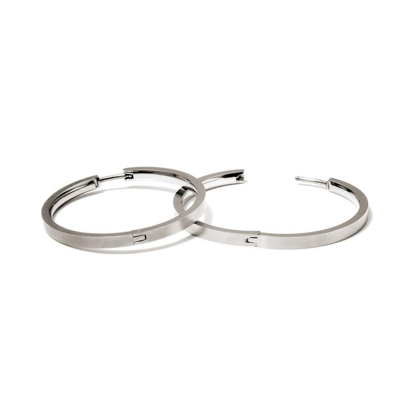 Boucles d'oreilles en titane argenté, de forme ronde et lisse, avec une finition mate.