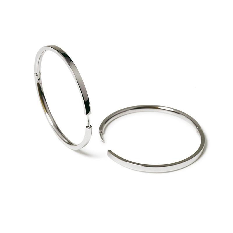 Boucles d'oreilles en titane argenté, de forme ronde et ouverte, avec une finition lisse.