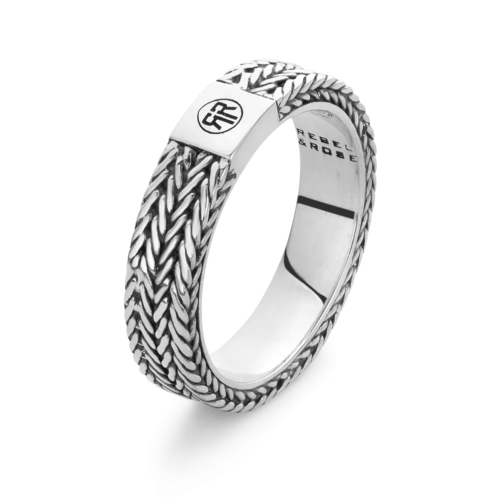 Bague en argent avec motif tressé et un symbole au centre.
