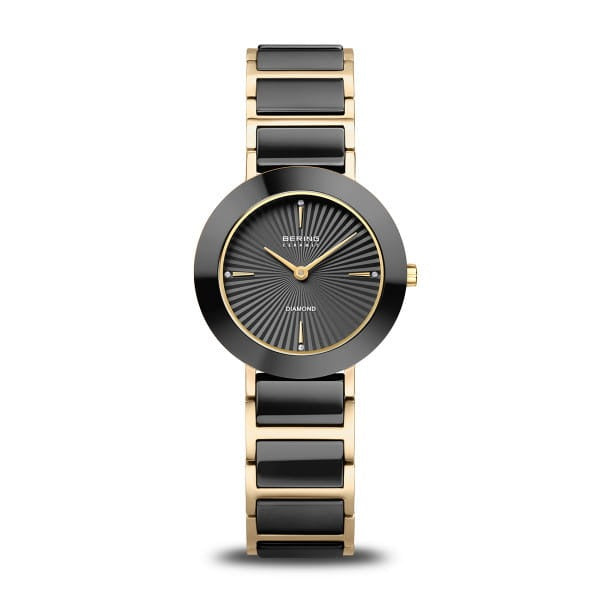 Montre femme avec cadran noir, boîtier doré et bracelet en acier noir.