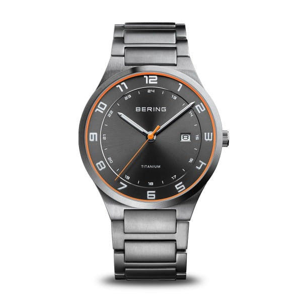 Montre en titane avec cadran gris, bracelet en acier inoxydable et détails orange.