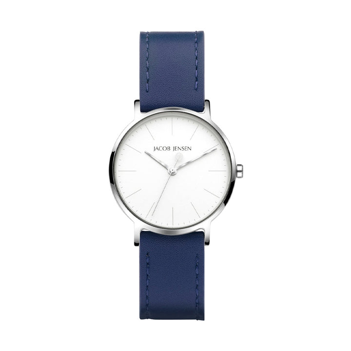 Het Jacob Jensen 173 polshorloge heeft een minimalistisch design met een witte ronde wijzerplaat, zilveren markeringen en twee wijzers. Het heeft een zilveren kast met een blauwe leren band.