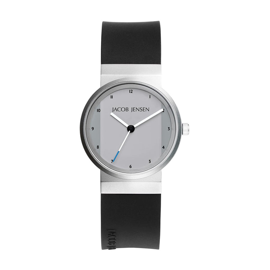 Montre en acier inoxydable avec cadran gris, bracelet en silicone noir et aiguilles argentées.
