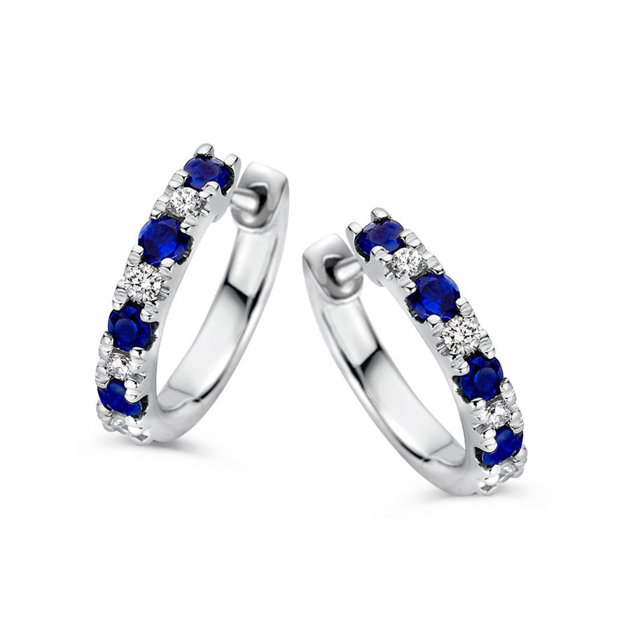 Boucles d'oreilles en or blanc avec des saphirs bleus et des diamants, ornées de pierres précieuses.