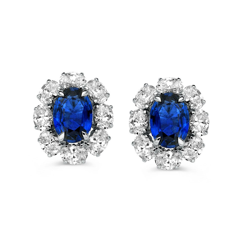 Boucles d'oreilles bicolores avec saphir central et diamants entourants.