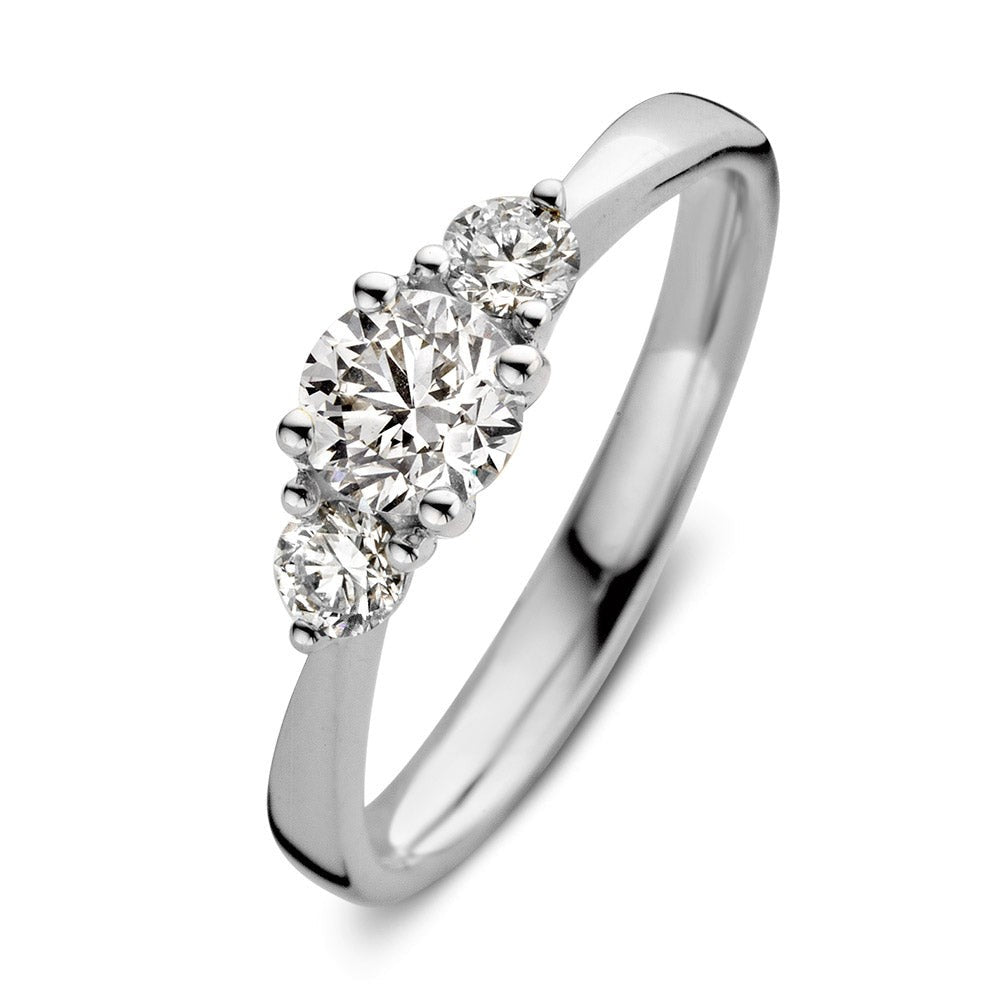 Bague en or blanc avec trois diamants brillants, dont un central plus grand.
