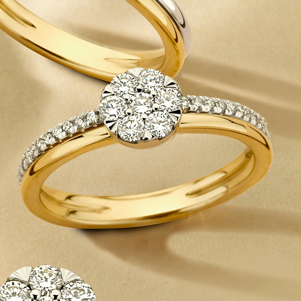 Bague bicolore en or avec un brillant central et des diamants sur le côté.