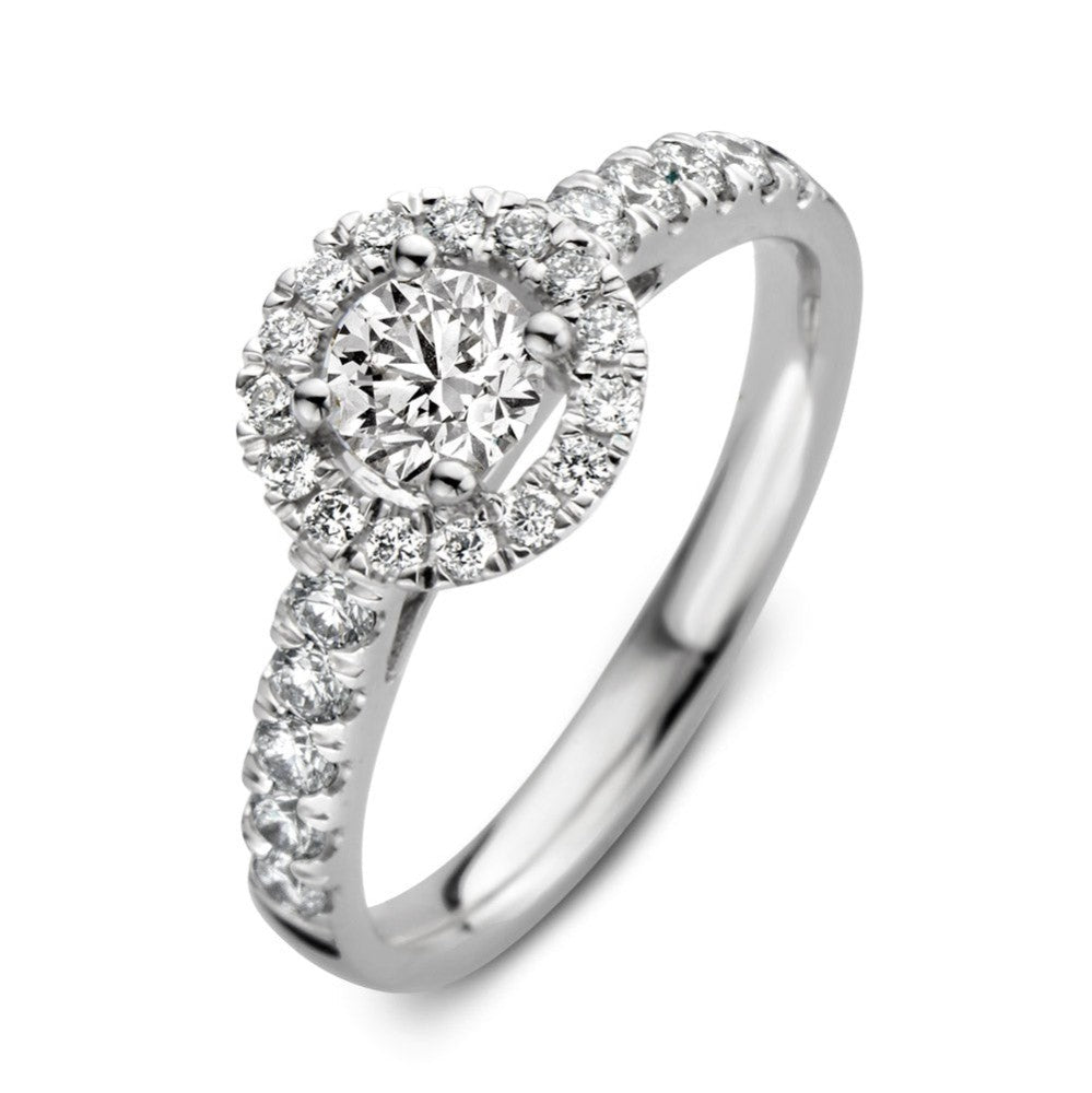 Bague en or blanc avec un diamant central et un halo de petits diamants.
