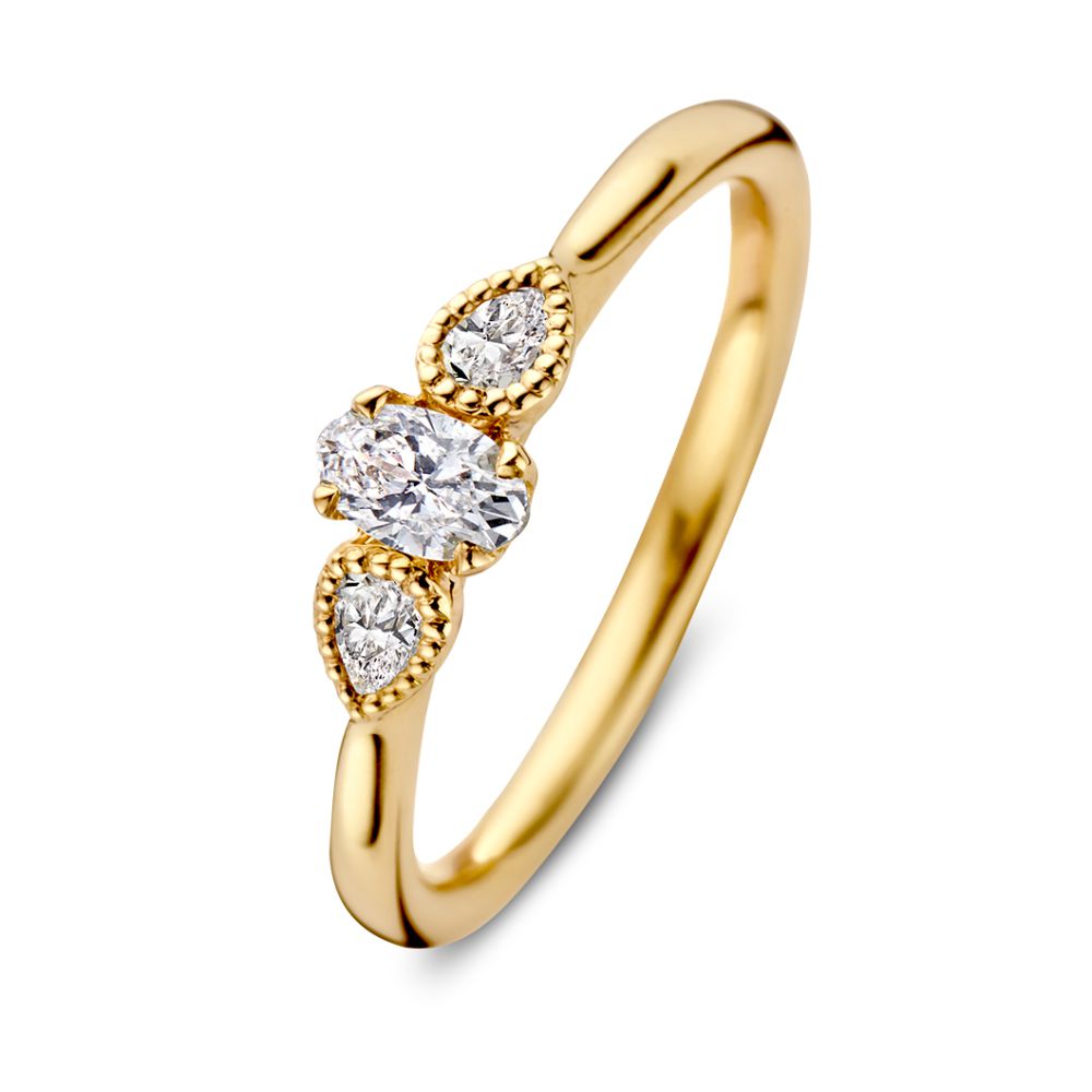 Bague en or jaune vintage avec un diamant ovale et deux pierres taillées en poire.