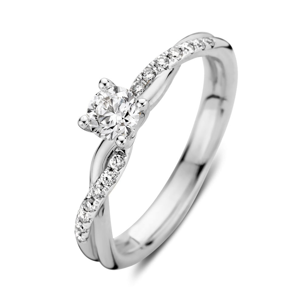 Bague en or blanc avec un diamant central et des diamants en pavé sur le corps.