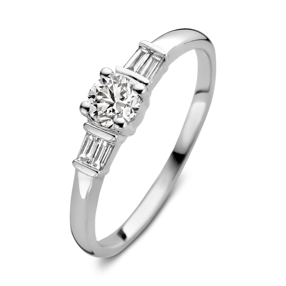 Bague en or blanc élégante avec un centre en diamant taille brillant et des pierres baguette sur les côtés.