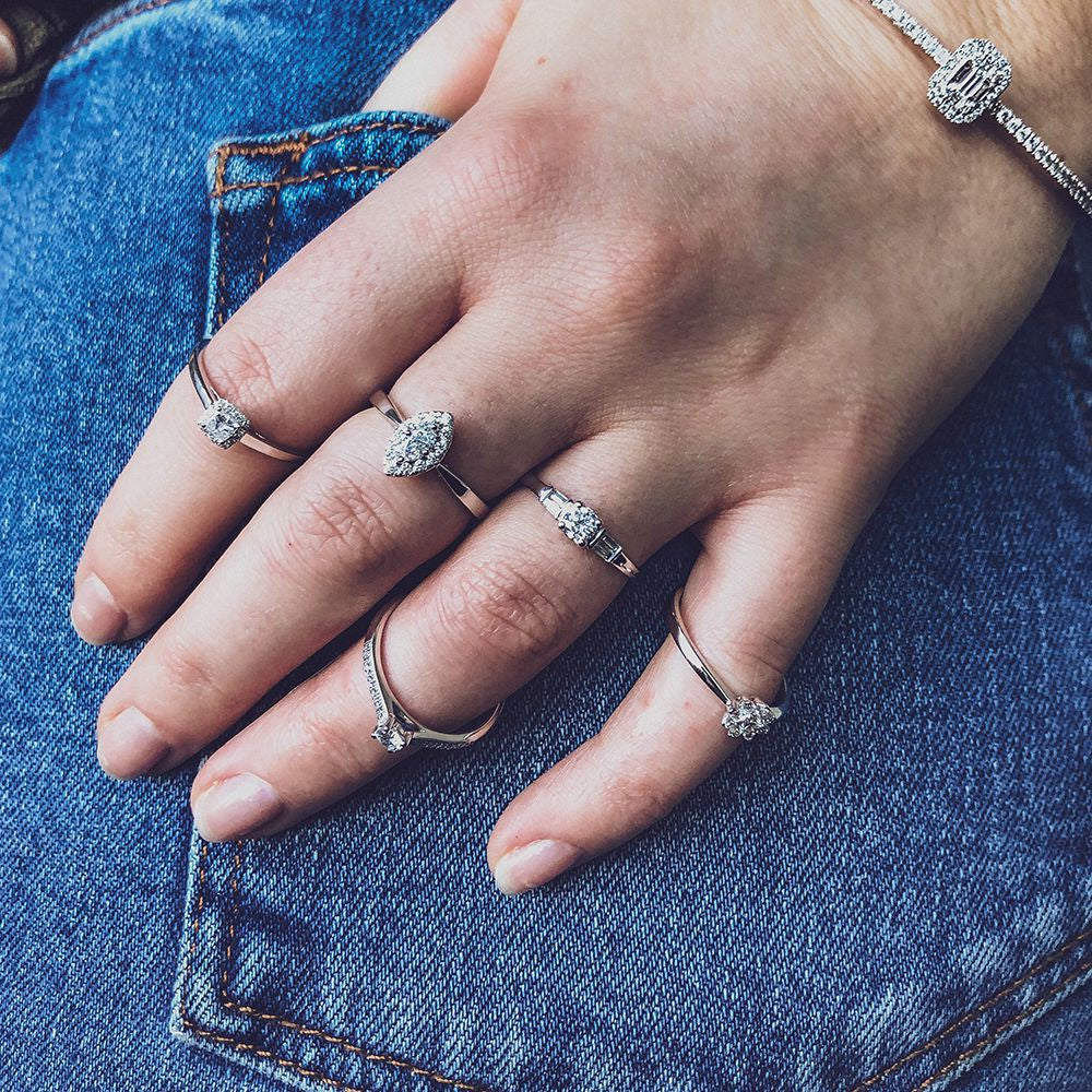 Bague en or blanc élégant avec centre en taille brillant et pierres latérales baguette