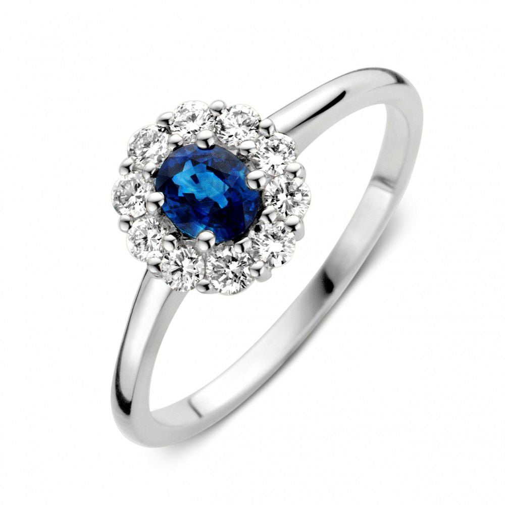 Bague en or blanc avec saphir bleu entouré de diamants.