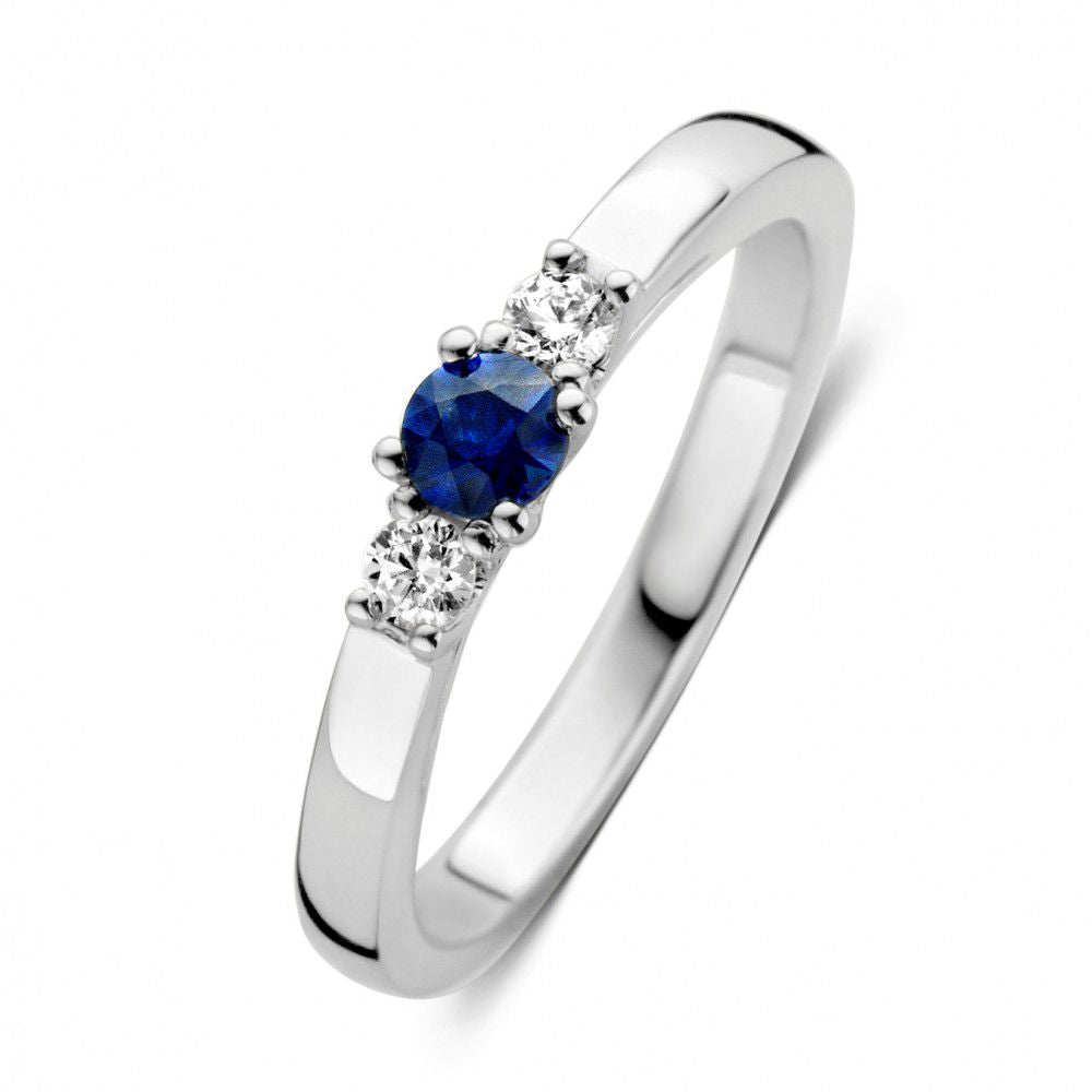 Bague en or blanc avec saphir central et diamants sur les côtés.