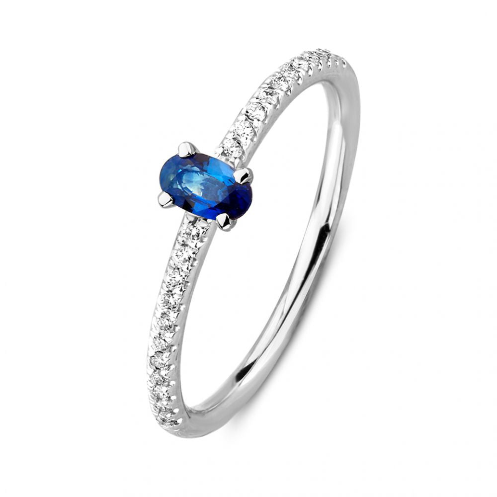 Bague en or blanc avec saphir ovale et diamants sertis sur le côté.