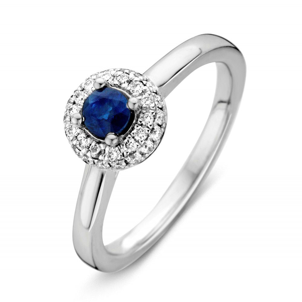 Bague en or blanc pour femme avec saphir central et diamants entourants.