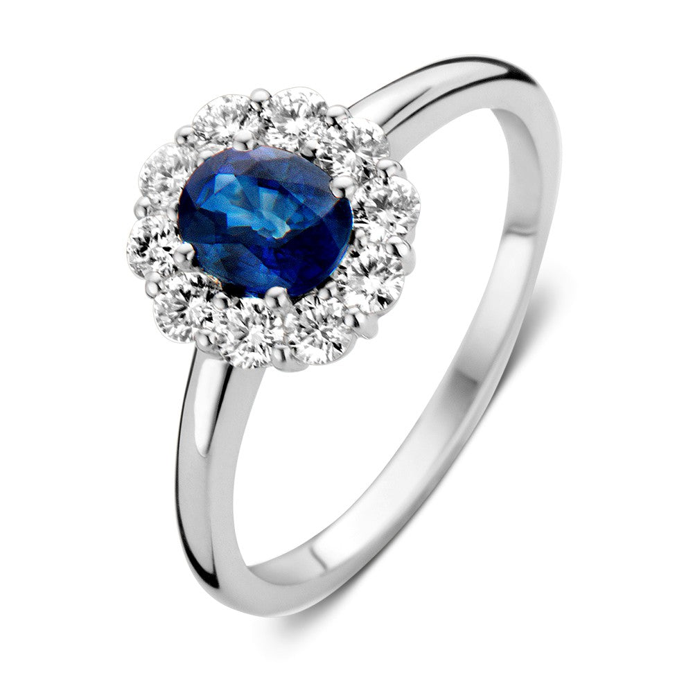 Bague en or blanc avec saphir bleu et diamants, sertie dans un cadre classique.