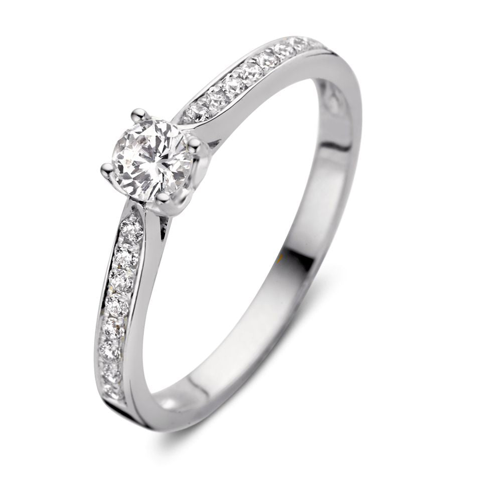 Bague en or blanc avec un cœur en zircon et des pierres scintillantes sur le côté.