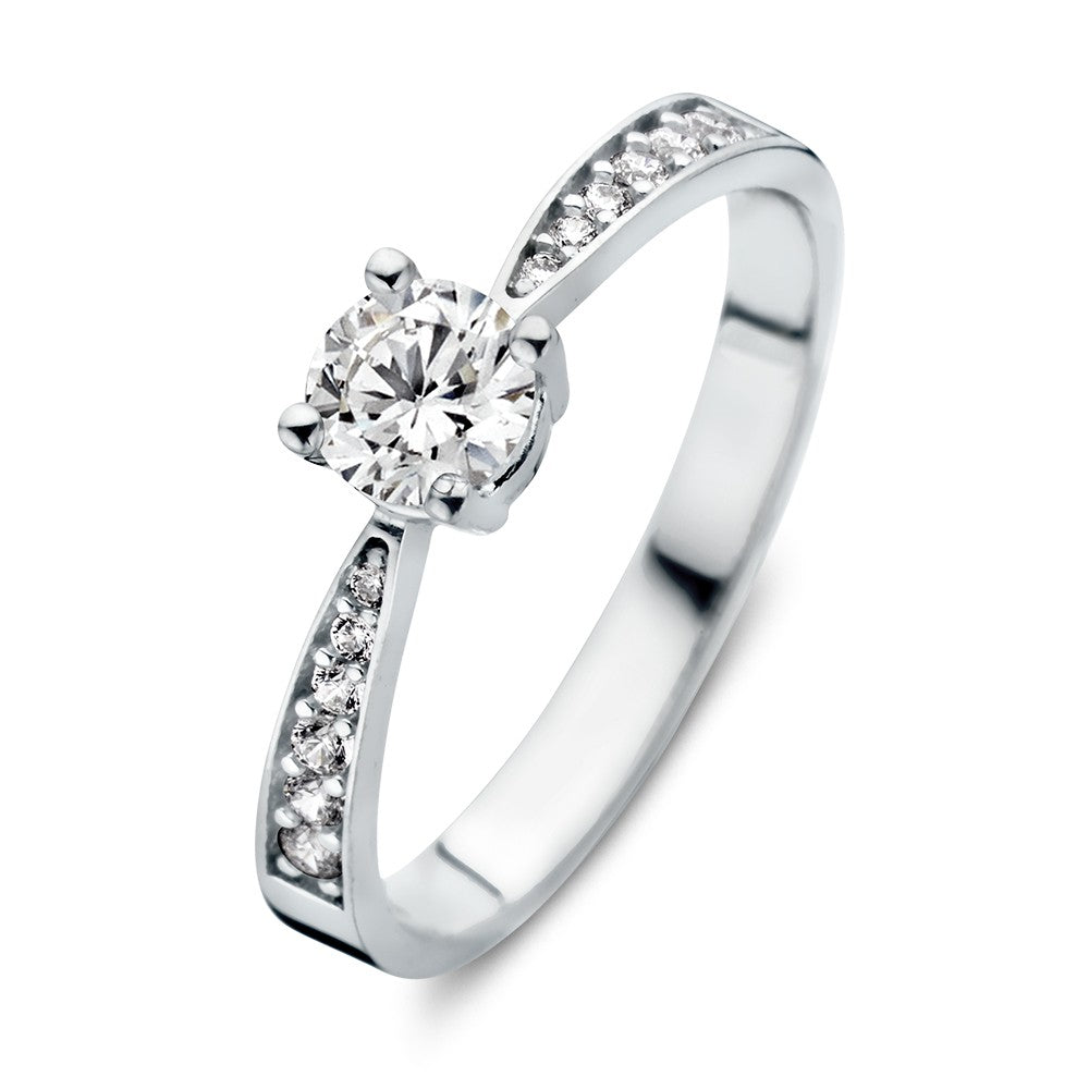 Bague en or blanc élégante avec des zirconias, sertie d'une pierre centrale et de petites pierres sur les côtés.