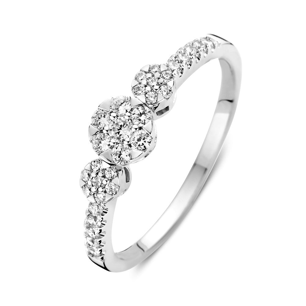 Bague en or blanc avec trois pierres de zircon et des pierres latérales.