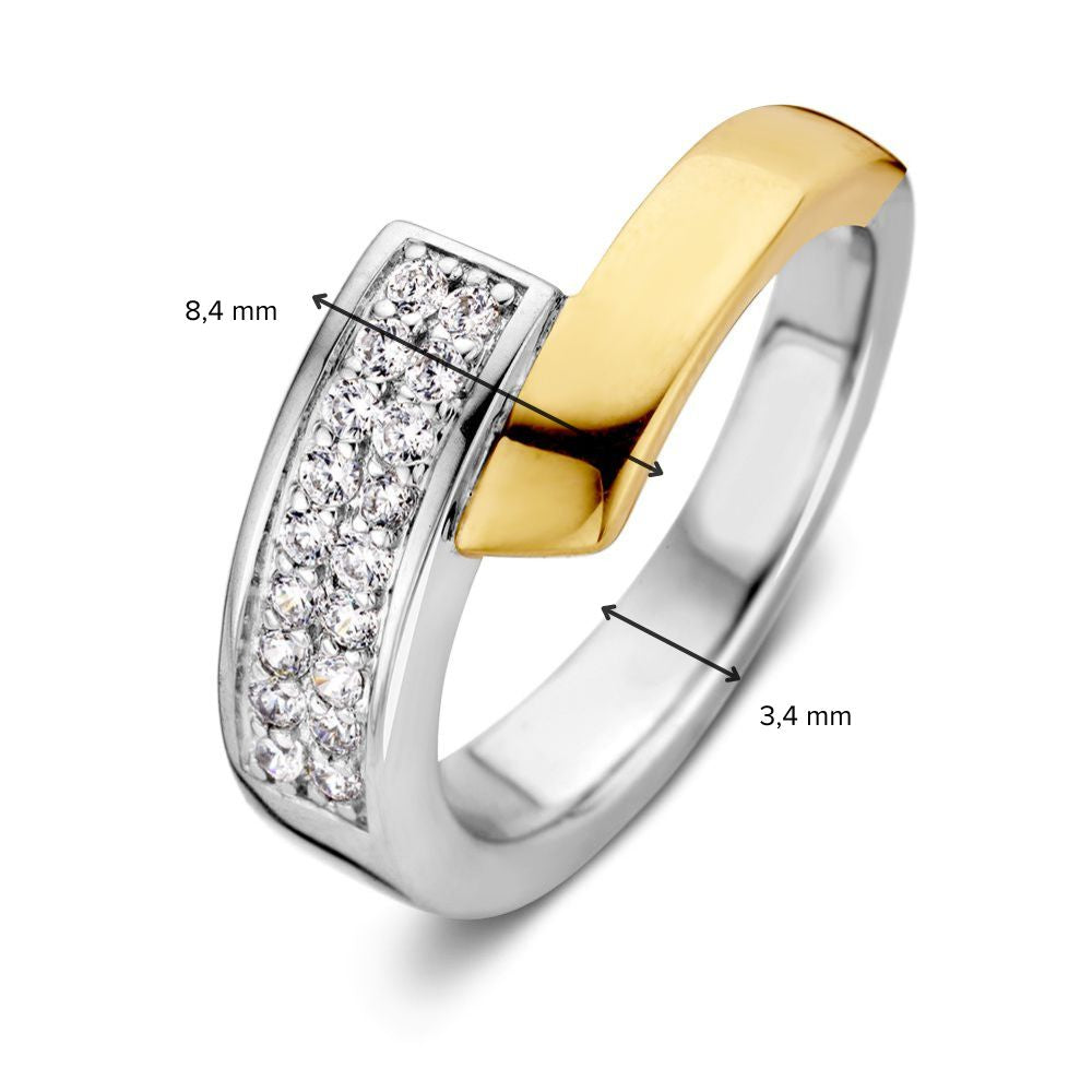De Elegante Zilveren Damesring met 14 Karaat Geel Goud en Zirkonia van Excellent Jewelry is een stijlvolle ring met wit- en geelgoudaccenten. Eén zijde met zirkonia is 8,4 mm breed; de andere zijde meet 3,4 mm.