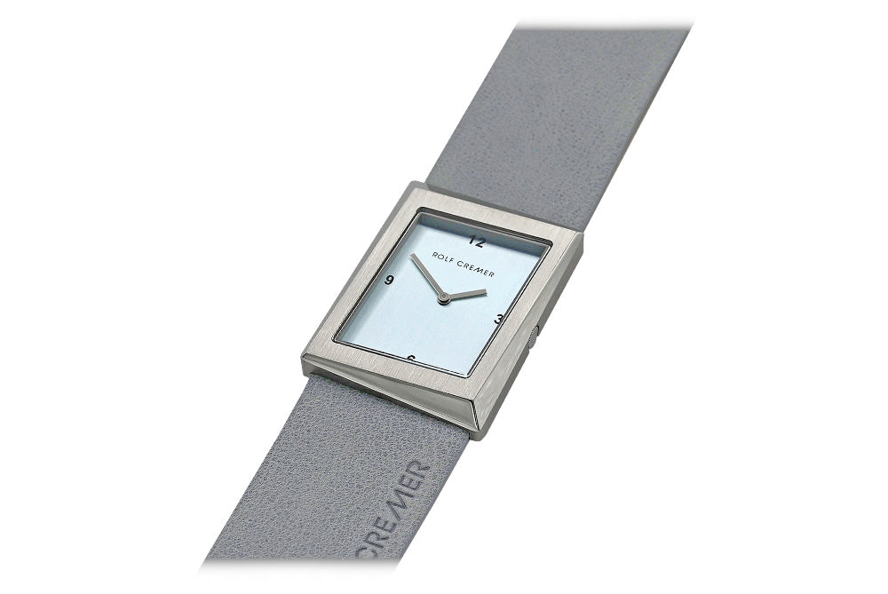 Montre carrée en acier inoxydable avec cadran bleu clair et bracelet en cuir gris.