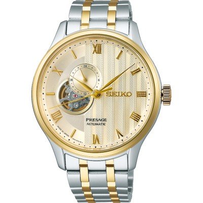 Montre Seiko Presage pour homme avec boîtier argenté et doré, cadran doré et bracelet en acier inoxydable.