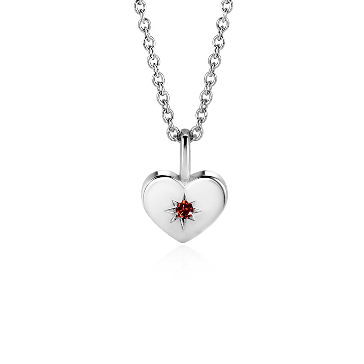 pendentif en forme de cœur en argent avec une pierre rouge au centre, suspendu à une chaîne argentée.
