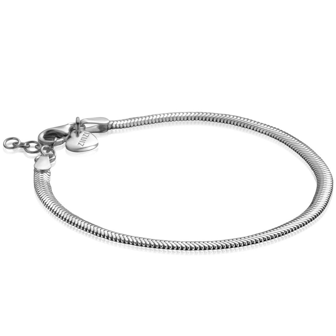 De Zinzi Armband Zilver Zia2402 is een zilveren slangenkettingarmband met een hartvormig I AM-bedeltje, karabijnsluiting en een elegant ontwerp dat het reflecterende, gladde oppervlak benadrukt.