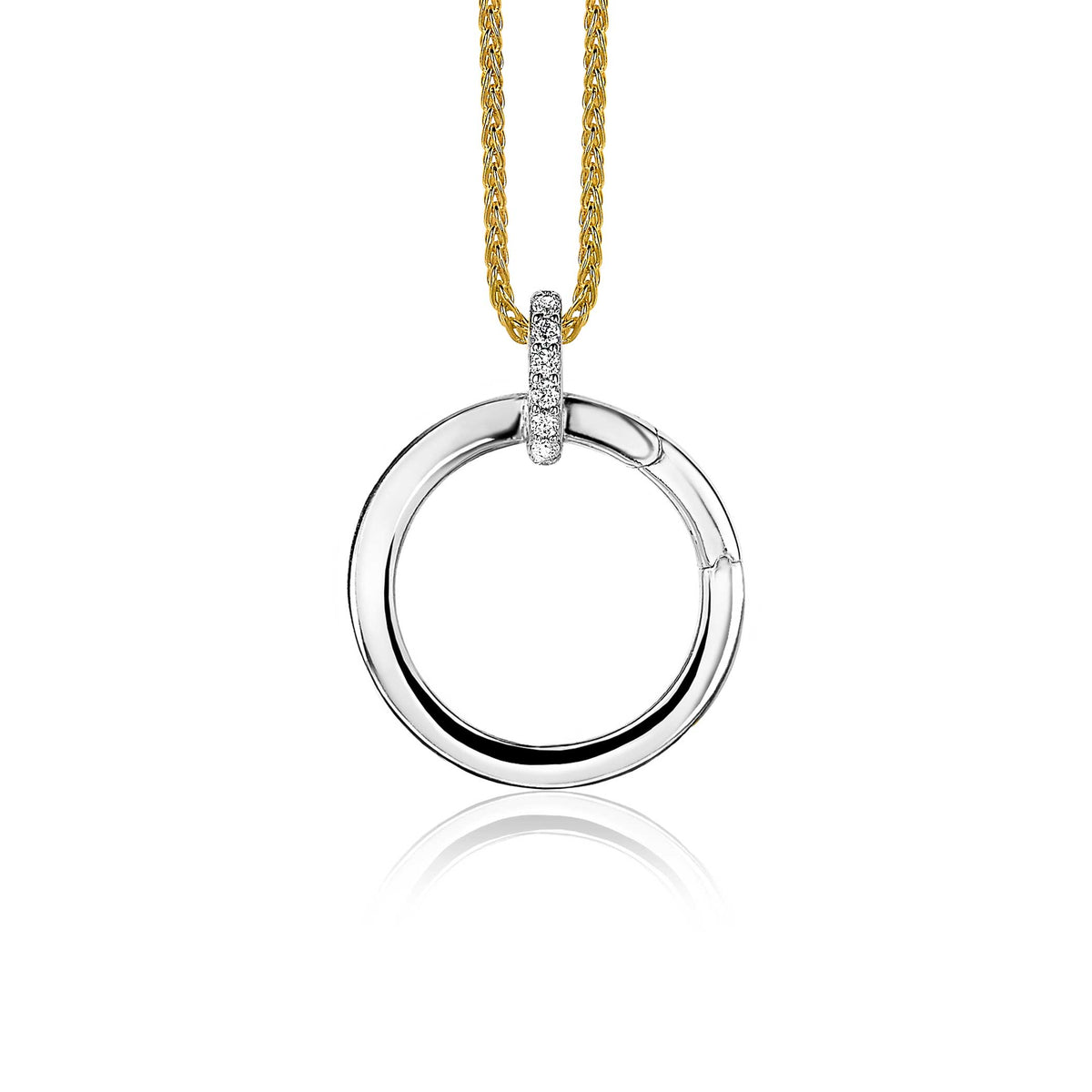 Pendentif en argent avec un cercle lisse et un détail en pierres brillantes, suspendu à une chaîne dorée.