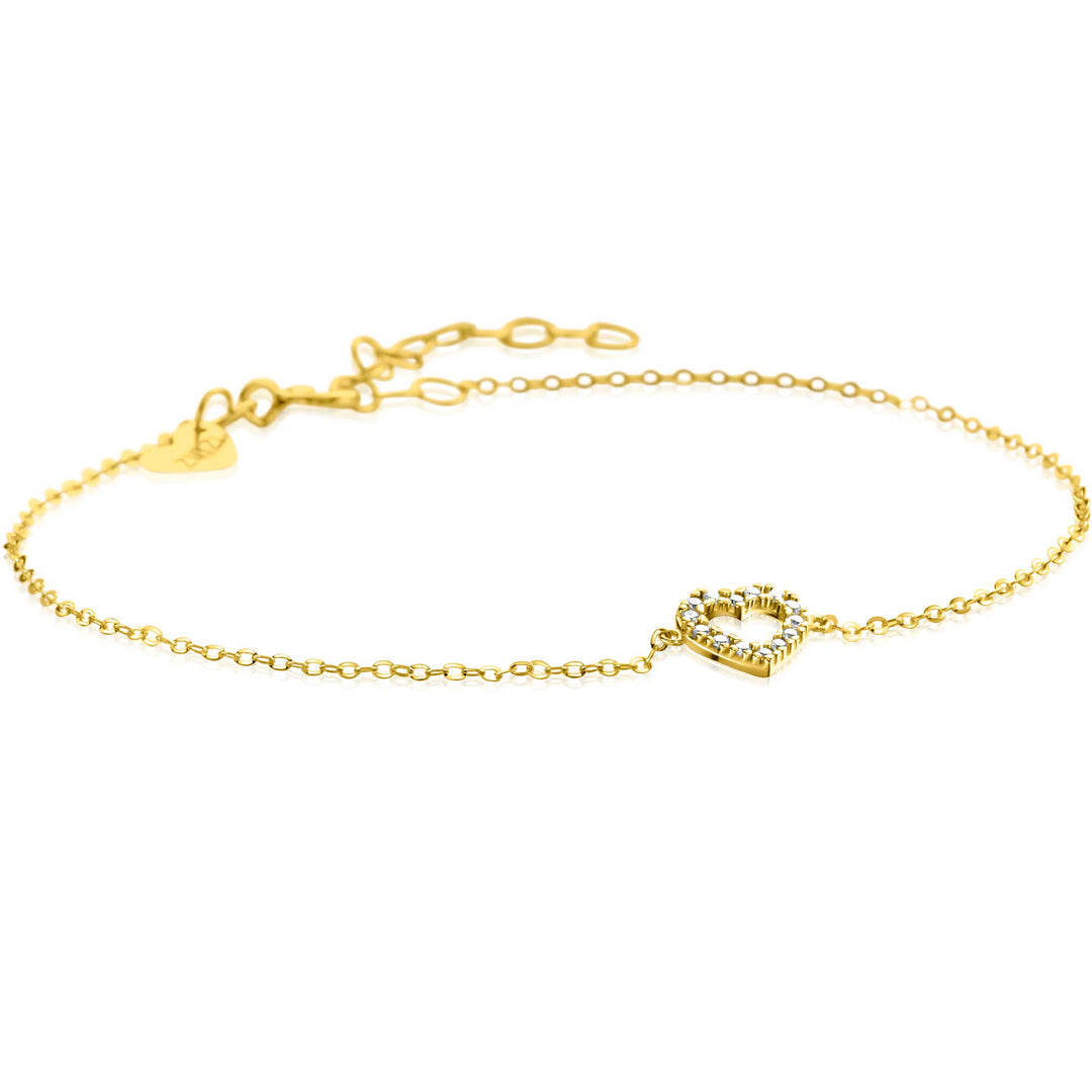 De Zinzi Armband Goud Zga450 is een delicate gouden armband met een hartvormige bedel versierd met kleine diamanten. De verstelbare ketting met een sluiting versierd met een klein hart rust zachtjes op een witte achtergrond, wat doet denken aan de elegantie die geassocieerd wordt met Zinzi.