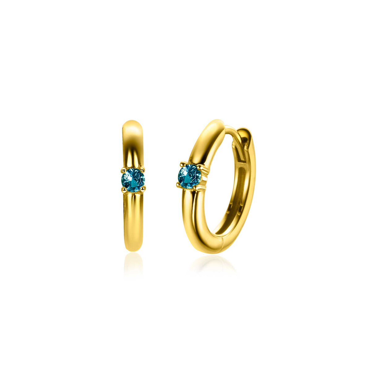 Boucles d'oreilles dorées avec un petit cristal bleu au centre.