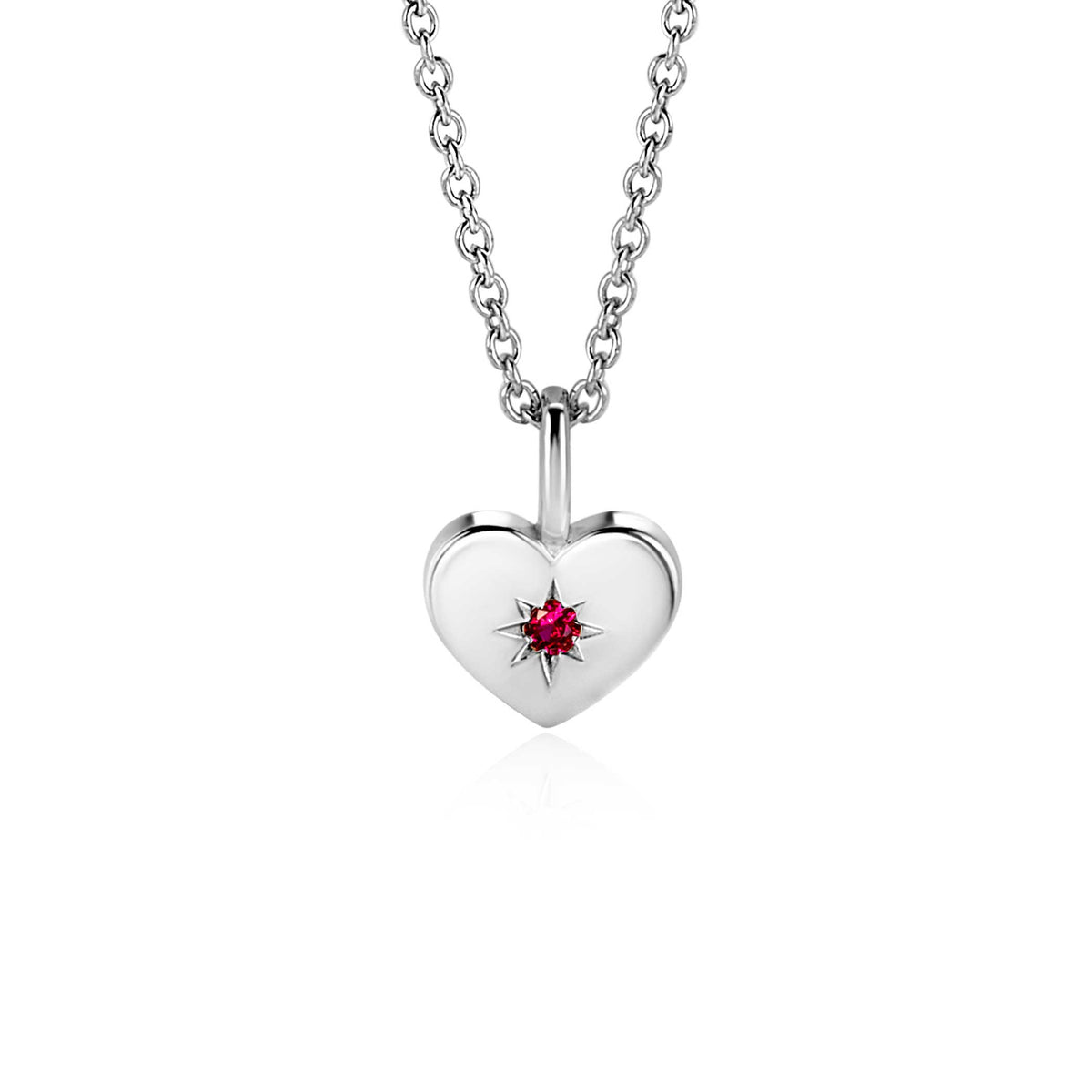 Pendentif en forme de cœur en argent avec un zircon rouge au centre, suspendu à une chaîne.