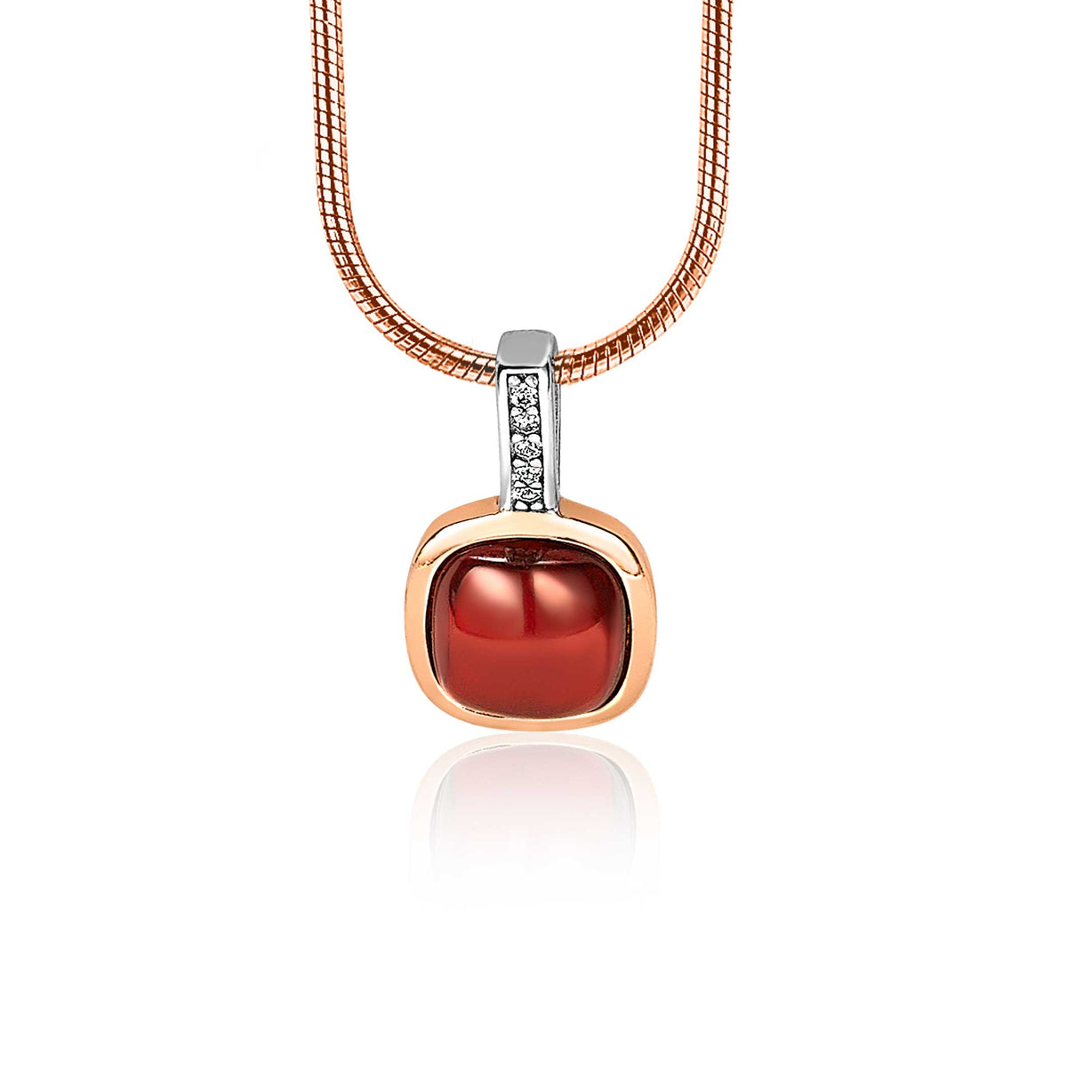 Pendentif en métal doré avec une pierre rouge et des détails en strass.
