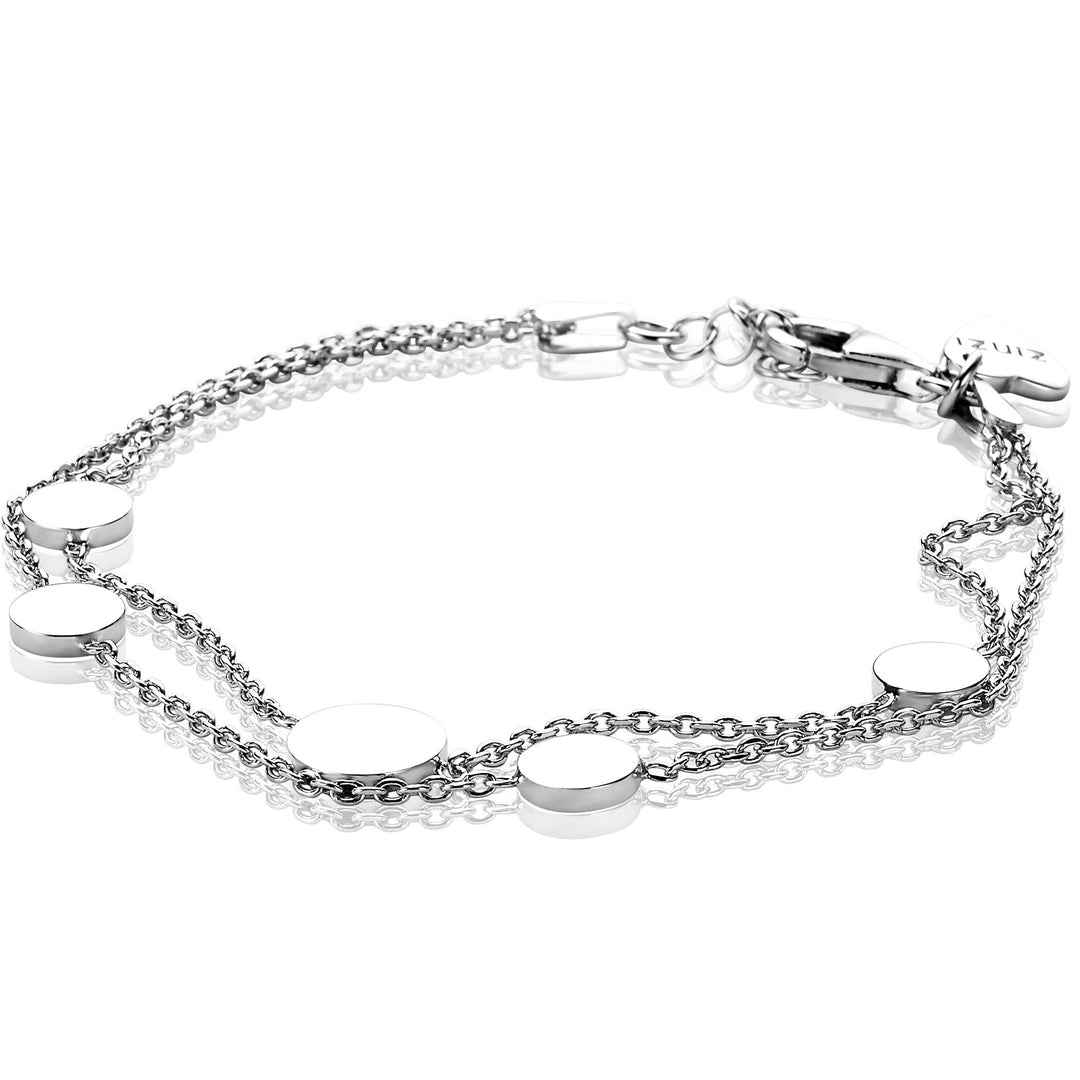 De Zinzi Armband Zilver Zia1808 is een zilveren armband met twee dunne kettingen en vijf gelijkmatig verdeelde ronde, platte schijven. Het heeft een karabijnsluiting en een klein rechthoekig label, wat eenvoudige elegantie laat zien.