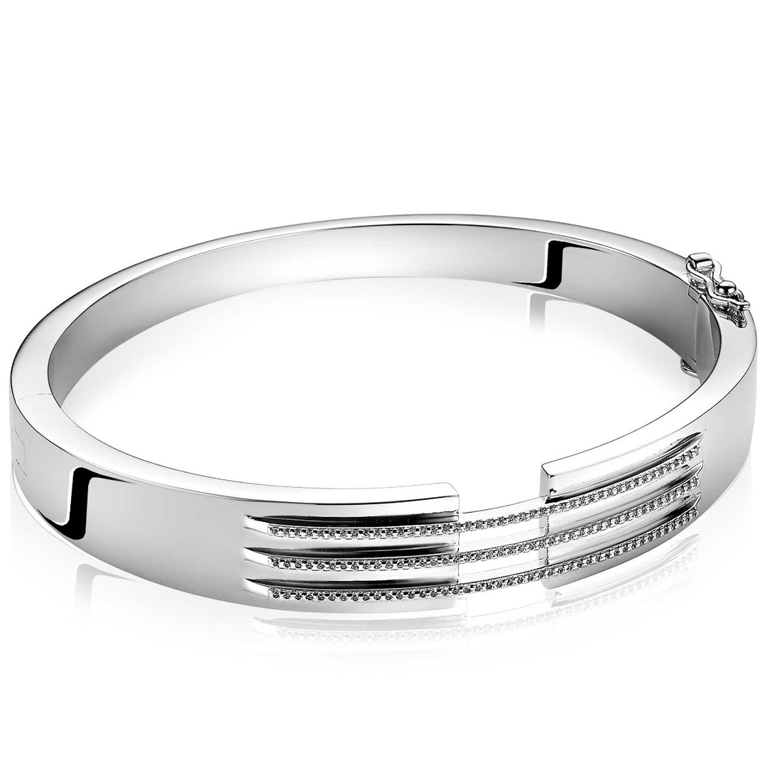 De Zinzi Armband Zilver Mva18, een strakke zilveren armband van Mart Visser voor ZINZI, heeft drie parallelle rijen edelstenen, waaronder witte zirkonias. Deze zilveren bangle voegt sprankeling toe en straalt moderne elegantie uit met zijn scharniersluitingontwerp.