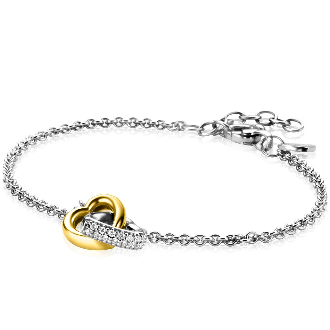 De Zinzi Armband Zilver Zia2276 heeft een tweekleurige schakel met een in elkaar grijpend hartontwerp, één in goud en de andere met diamanten. Het heeft een verstelbare sluiting en extra schakels, die twee harten verbonden belichamen.