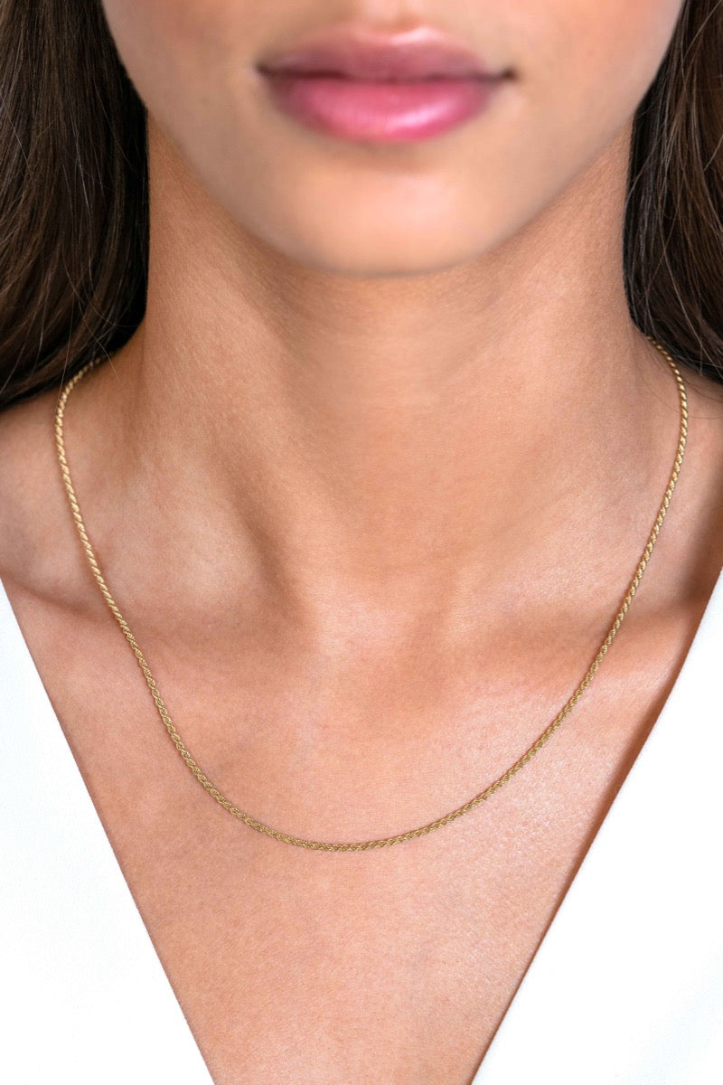 Collier doré en métal avec une chaîne délicate et lisse.